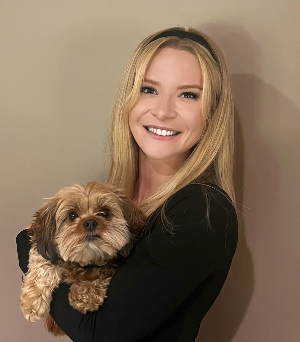 Lexie Whitten, founder of Elevate Animal Care, holding a small dog — in-home pet sitting in Denver